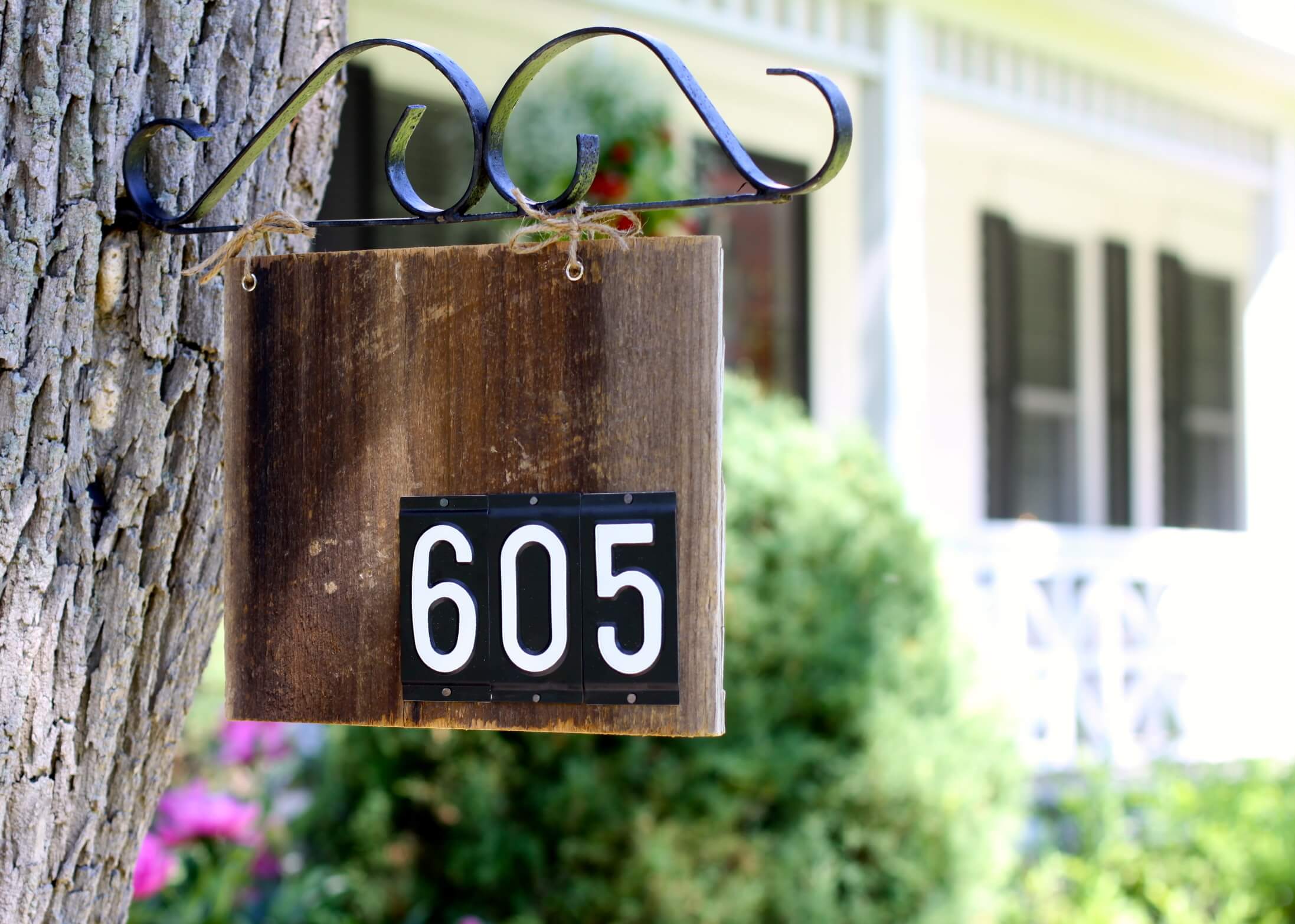 House Number Sign Hanging from a Tree