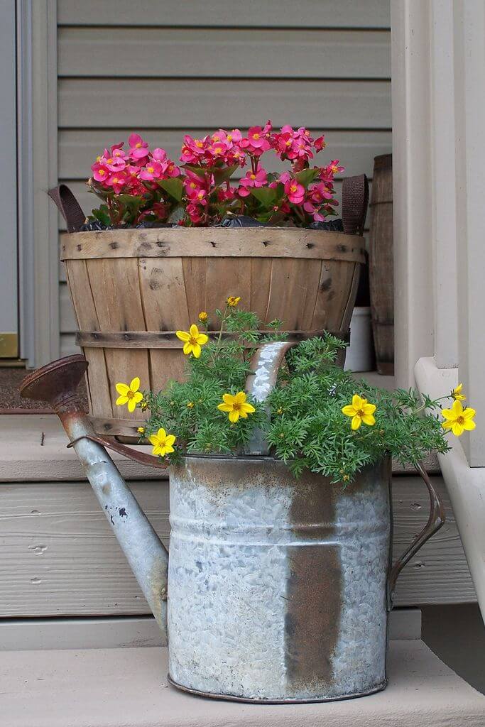 rosa och gula blommor i ett fat och vattenburkar