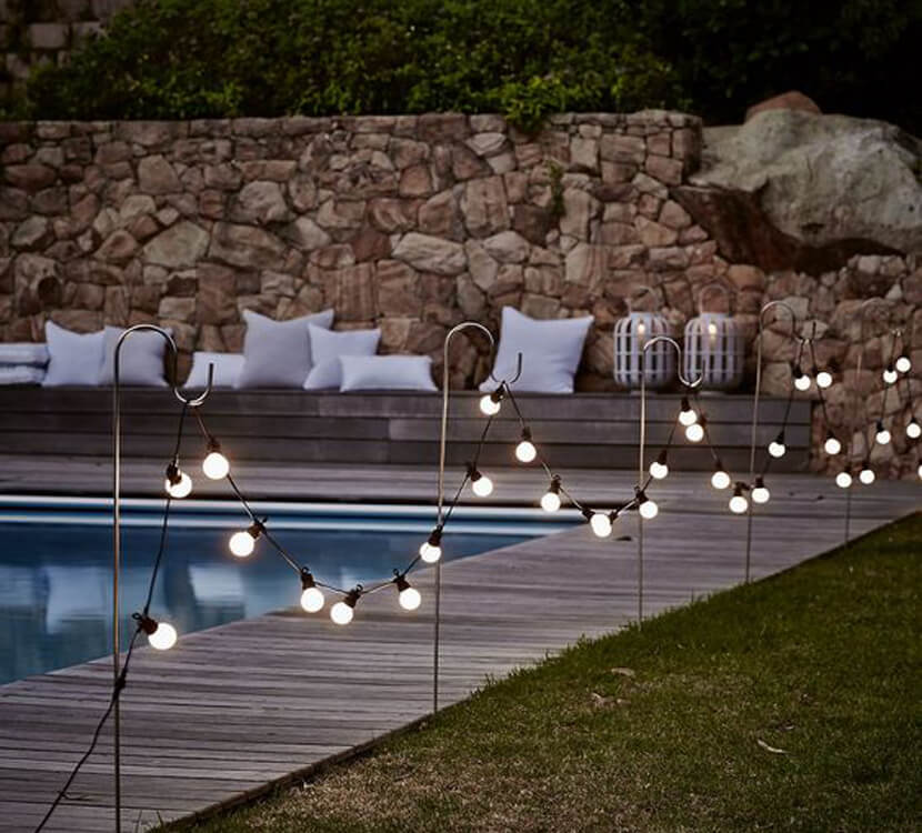 Globe Lights Hung On Hooks by the Pool