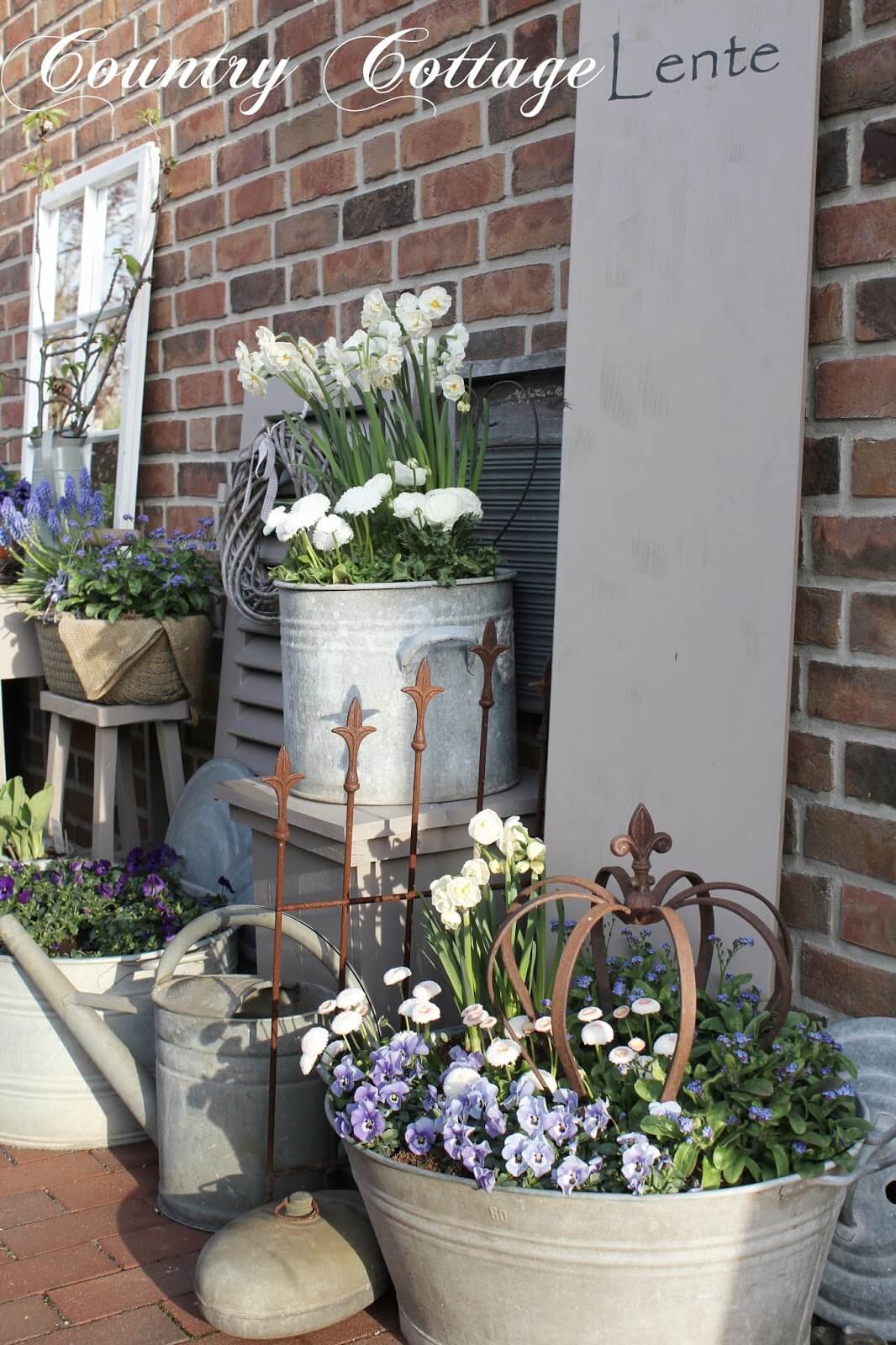 een assortiment van metalen plantenbakken met bloemen