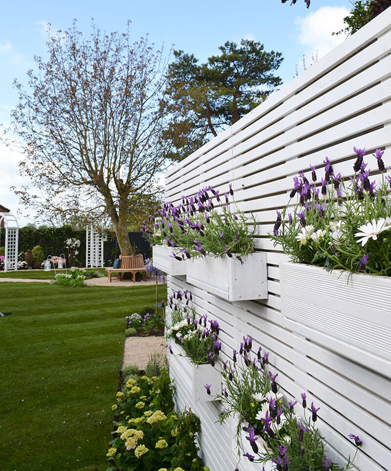 Stacked Window Boxes on a White Fence